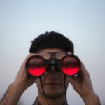 a man with binoculars resembeling assurance